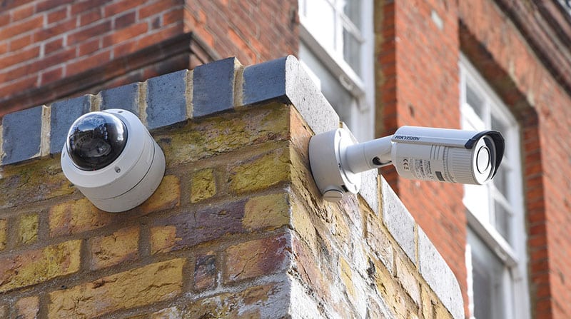 CCTV cameras mounted on the exterior brick walls of a commercial property